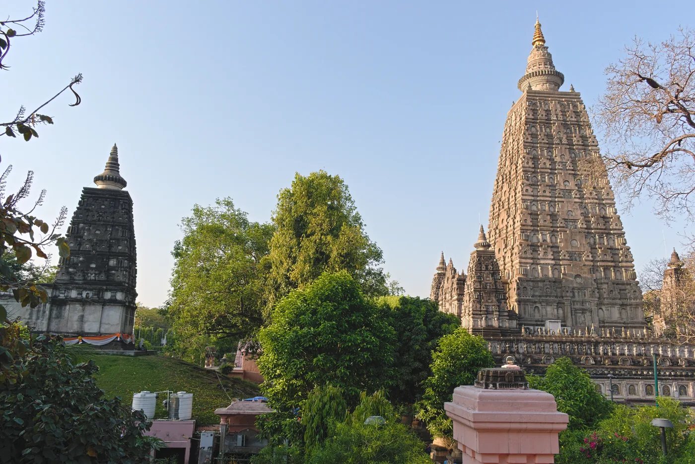 The tall pyramidal tower of the Mahabodhi Temple at Bodh Gaya rising above a courtyard with pilgrims