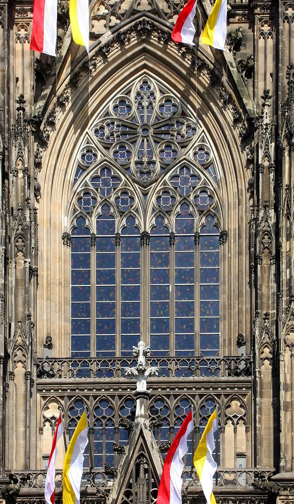 The tall Gothic south transept window of Cologne Cathedral seen from outside, its tracery filled with Richter’s small coloured squares